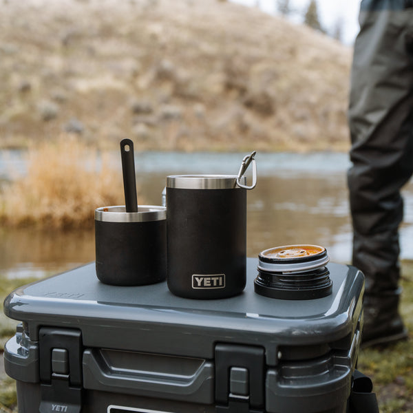 YETI brand tumblers on a cooler with a natural outdoor background
